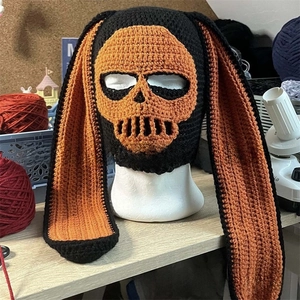 Detail of handmade knit balaclava with orange skull face and long rabbit ears