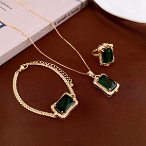 Detailed set of gold necklace, bracelet, and ring with emerald cut green zircon stones