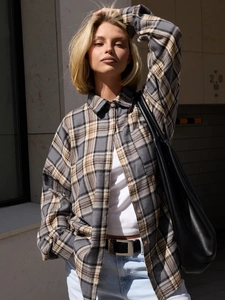 Detail of grey and beige plaid long-sleeve cotton shirt with texture in natural light