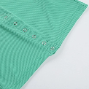 Close-up of green ribbed knit fabric featuring metallic silver snap buttons detail