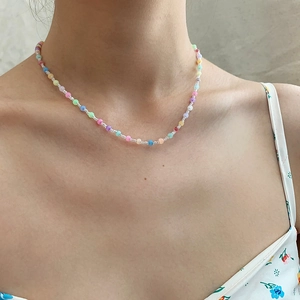 Close-up of colorful beaded choker necklace on model's neck for a trendy summer look