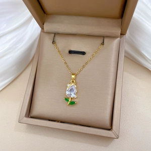 Macro detail of tulip pendant with sparkling teardrop zircon on gold chain in gift box