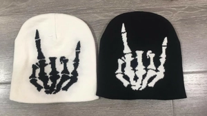 Vue détaillée de deux bonnets en tricot avec broderie main de squelette rock en noir et blanc