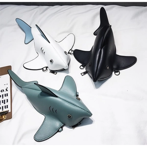 Detailed close-up of creative shark-shaped crossbody bags in black, white, and grey-green
