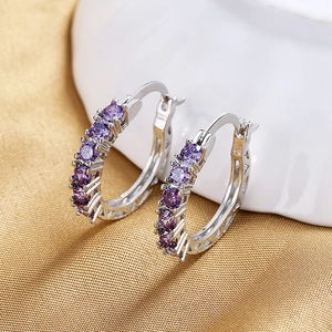 Macro detail of silver pearl earrings with purple zircon and 925 silver engraving