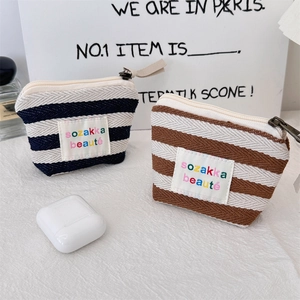 Close-up of small striped canvas cosmetic pouches with zipper and sozakka labels
