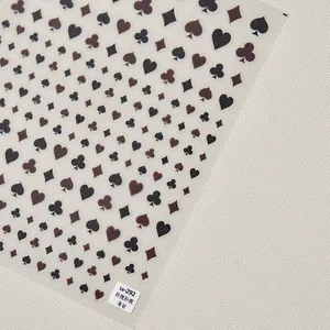 Vue macro de stickers nail art ultra-fins avec motifs de cartes de poker noirs et rouges