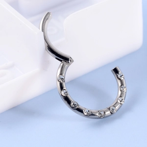 Macro shot of silver stainless steel piercing ring with hinged clasp and cubic zirconia