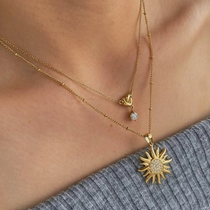 Collier double couche en acier inoxydable doré avec pendentifs soleil et cœur sur mannequin