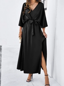 Detailed view of black V-neck satin dress featuring batwing sleeves and high side slit