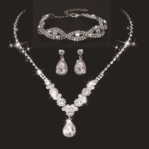Macro view of bridal jewelry set with sparkling pear-shaped rhinestones on black background