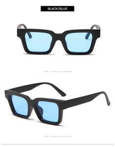 Detail view of bold black square sunglasses with light blue transparent lenses