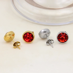 Macro shot of gold and silver titanium earrings with brilliant round-cut red crystals