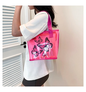 Close-up of pink transparent PVC tote bag featuring black butterfly print and wide straps