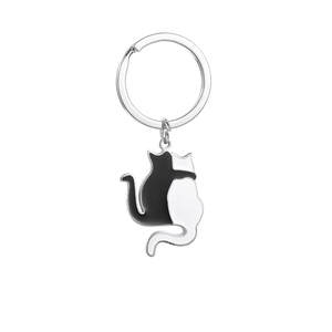 Close-up of interlocking black and white metal cat charms on a silver keychain