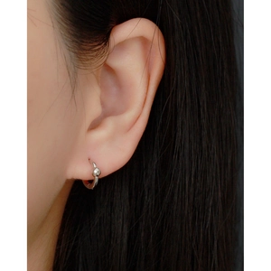 Close-up of minimalist S925 sterling silver hoop earrings worn on a model's ear