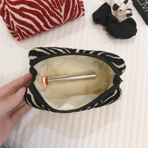 Detail view of the zebra stripe knit pouch showing interior lining and zipper closure