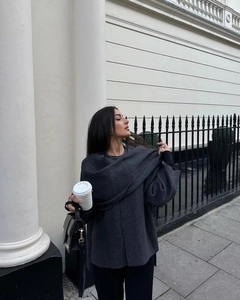Detail of dark gray knitted shawl cape with premium wool texture for women in autumn