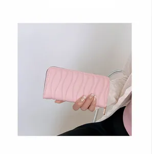Detailed view of women long pink wallet featuring a textured wave pattern and zipper closure