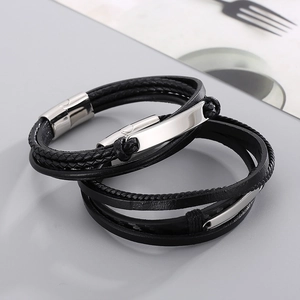 Macro detail of multi-layer black braided leather bracelet with magnetic steel clasp