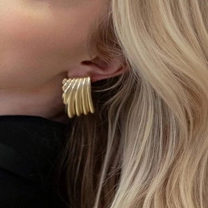 Nahaufnahme von Damen-Ohrringen aus 18K vergoldetem Edelstahl mit gewelltem Texturdesign