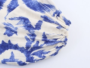 Detailed close-up of elasticated cuffs with blue and white abstract print on fabric