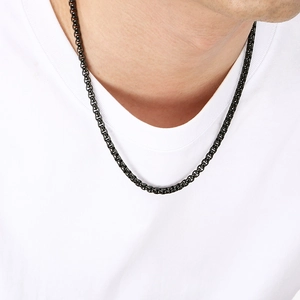 Gros plan d'un collier chaîne noir minimaliste en acier inoxydable porté par un mannequin