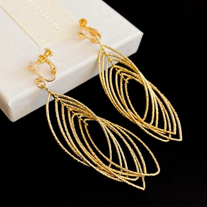 Detailed shot of golden layered leaf ear clips featuring anti-pain silicone pads and hammered texture