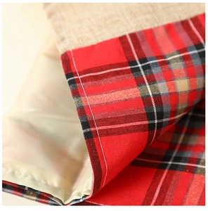 Macro detail of Christmas linen runner showing red black plaid and beige burlap texture