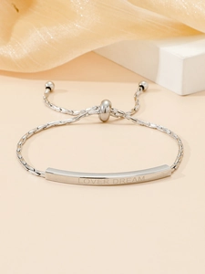 Close-up of silver titanium steel bracelet with engraved LOVER DREAM bar and adjustable slide