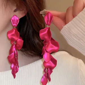 Long rose red leaf petal drop earrings with elegant matte finish shown on model