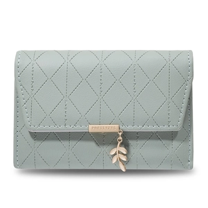 Detail of light green PU leather wallet featuring leaf pendant and metal logo tag