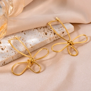 Minimalist gold bow earrings with twisted wire design on champagne silk backdrop