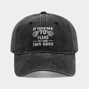 Detail of embroidered '70 YEARS TO LOOK THIS GOOD' on a black washed cotton baseball cap