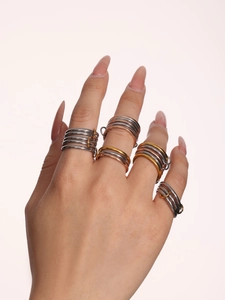 Detailed view of interconnected multi-color stainless steel rings with polished finish