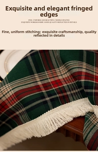 Detail of red and green plaid tablecloth with white fringe tassels and twill weave texture