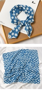 Close-up of blue cotton linen scarf with white daisy floral print and fine hemmed edges