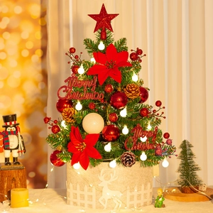 Close-up of 50cm tabletop Christmas tree with red poinsettias, warm lights and reindeer base