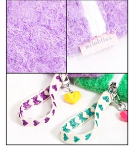 Detail of plush heart coin purse with brand tag and heart-shaped pendant accessory