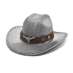 Détail d'un chapeau de cowboy argenté avec emblème de tête de taureau sur cuir