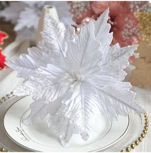 Close-up of a white artificial Christmas flower with sequins and glitter decoration