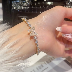 Dettaglio del bracciale a farfalla in cristallo con zirconi su uno sfondo lucente