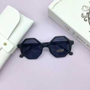 Detail of octagonal black kids sunglasses with UV 400 lenses and a white leather case