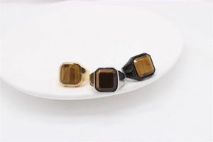 Three square tiger eye stones set in gold, silver, and black polished steel rings