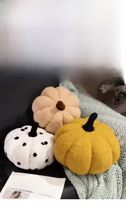 Close-up of fluffy pumpkin plush pillows in yellow and white on a cozy sofa setting