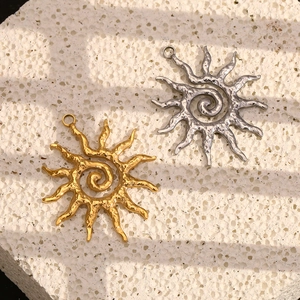 Gold and silver sun pendants with hammered texture on white stone background