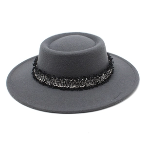 Detalle de sombrero de lana gris oscuro de copa plana con una banda trenzada elegante