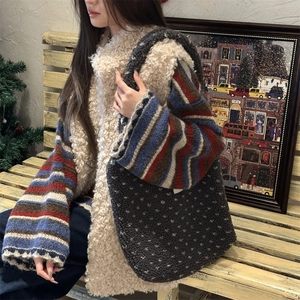 Detail of grey lamb wool heart tote bag paired with white faux fur vest and striped sweater
