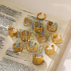 Set van 11 gouden ringen met gehamerd en geometrisch design op vintage boekpagina's