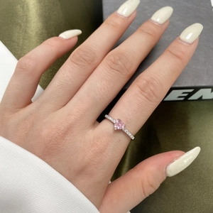 Gros plan d'une bague en argent S925 avec zircon rose en forme de cœur sur un doigt
